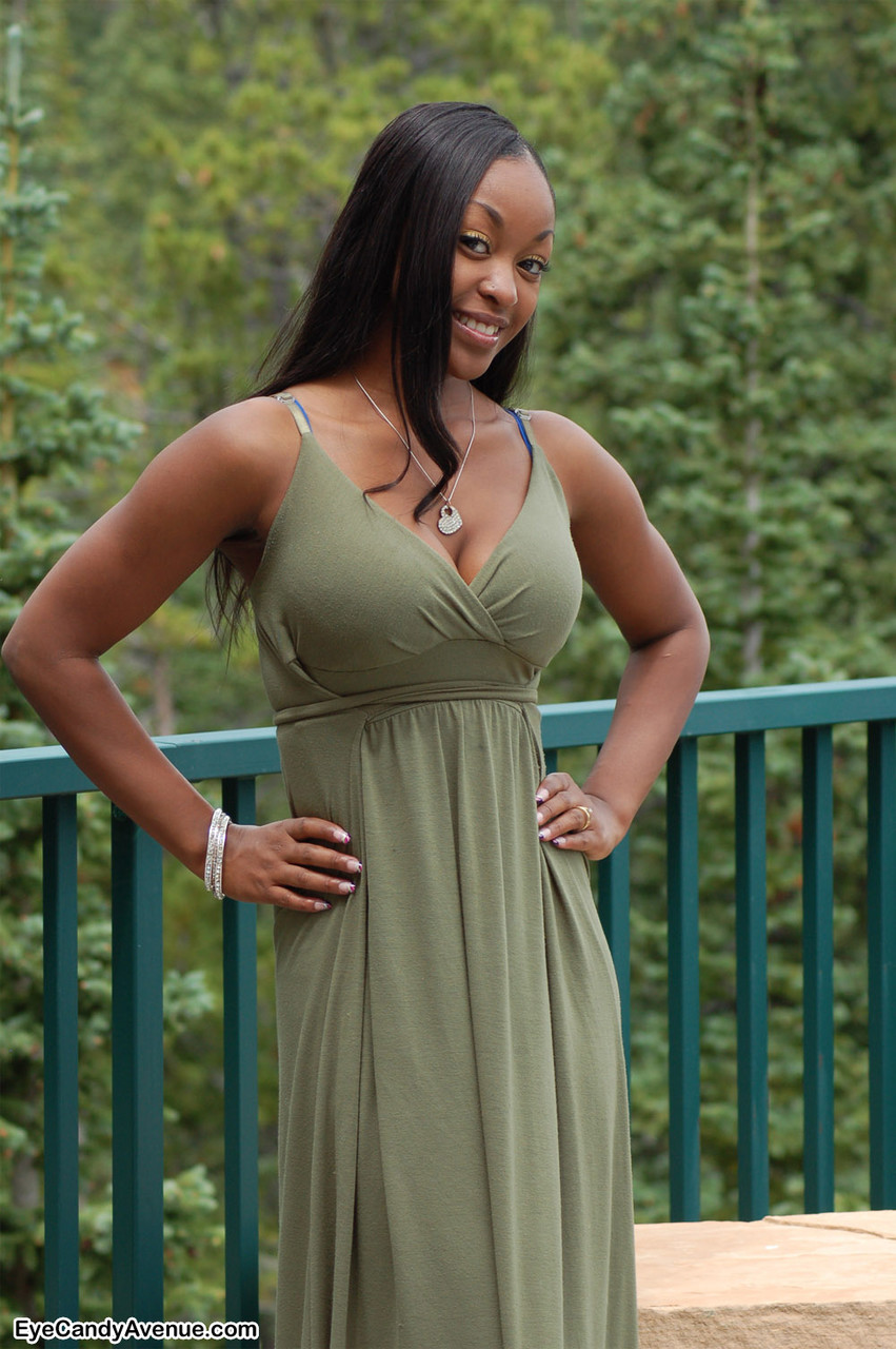 Ebony amateur Amber releases her big tits from a long dress on a balcony