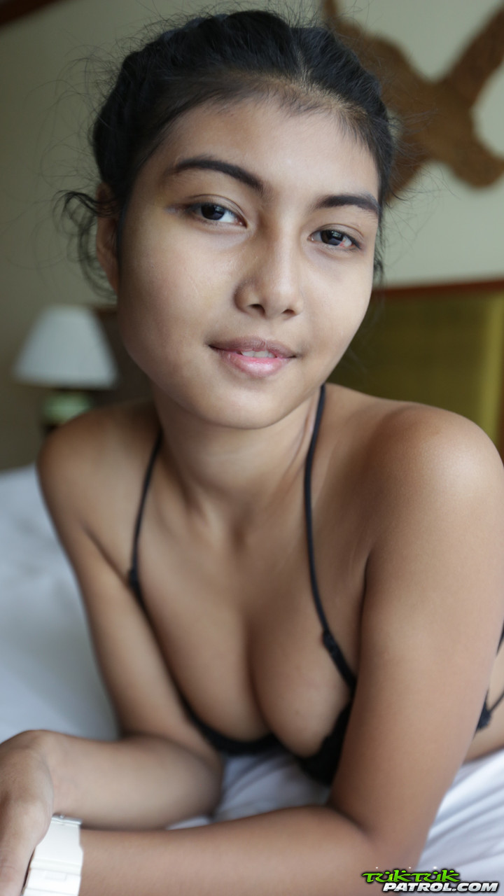 Petite Asian teen Pauw takes off her gown and flaunts her tits and hairy kitty